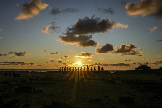 The sun rises behind a line of moais statues on Ahu Tongariki, Rapa Nui, or Easter Island, Chile, Saturday, November 26, 2022. (Photo by Esteban Felix/AP Photo)