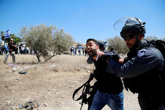 Israeli policemen detain an Arab Israeli as clashes with police erupted during a demonstration held by Israeli right-wing protesters (L) near the family home of Nashat Melhem, an Arab Israeli who killed three people in a Jan. 1 shooting attack, in the northern Arab Israeli village of Arara September 19, 2016. (Photo by Ammar Awad/Reuters)