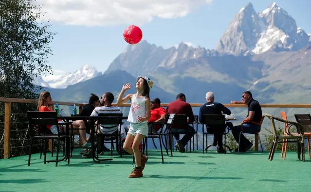 People enjoy their time on a terrace overlooking the mountains on a sunny day in the town of Mestia, some 400km west of the capital Tbilisi, Georgia, 06 August 2020. (Photo by Zurab Kurtsikidze/EPA/EFE)