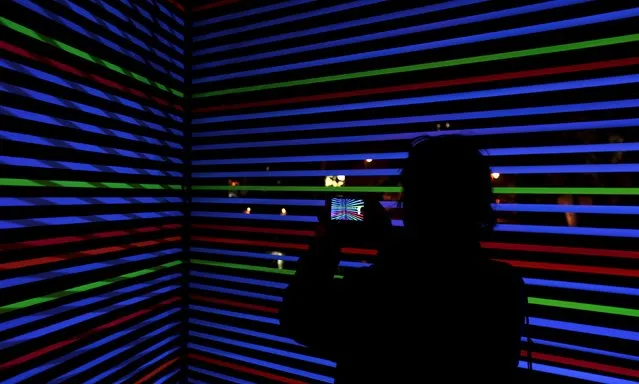 A man takes a picture of the installation "Horizontal Interference" during the Signal light festival in Prague, Czech Republic, October 15, 2015. (Photo by David W. Cerny/Reuters)