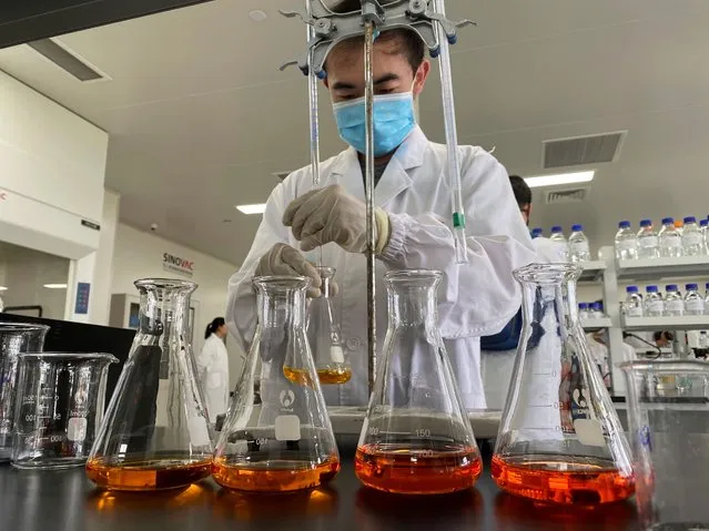 A worker works inside a lab at the SinoVac vaccine factory in Beijing on Thursday, September 24, 2020. SinoVac, one of China's pharmaceutical companies behind a leading COVID-19 vaccine candidate says its vaccine will be ready by early 2021 for distribution worldwide, including the U.S. (Photo by Ng Han Guan/AP Photo)