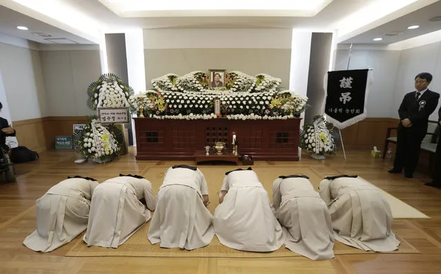 Roman Catholic sisters bow in front of a memorial altar for the late farmer activist Baek Nam-gi at the Seoul National University Hospital in Seoul, South Korea, Monday, September 26, 2016. Dozens of activists are commemorating Baek who died in the hospital almost a year after being knocked unconscious by water cannons during protests against South Korea's government. (Photo by Ahn Young-joon/AP Photo)