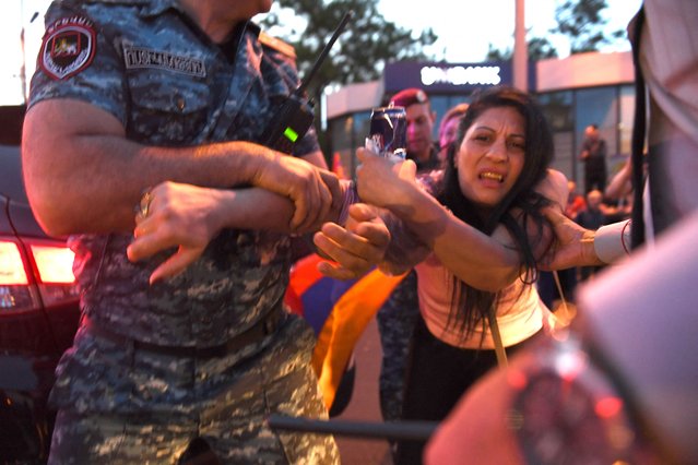 Armenian police officers detain a protester during a rally against land transfer to Azerbaijan, in Yerevan on April 30, 2024. The protesters are hoping to thwart Armenia's plans to return control of four abandoned Azerbaijani villages – seized during the 1990s – as part of wider talks on securing an elusive peace deal with Baku. The two Caucasus rivals have been locked in tension and bloody conflict since the break-up of the Soviet Union more than three decades ago. They fought two wars – in the 1990s and 2020 – for control over Nagorno-Karabakh, territory internationally recognised as Azerbaijan's but controlled for 30 years by Armenian separatists. Baku recaptured it in a lightning offensive last September, and talks over a broader border agreement have since intensified. (Photo by Karen Minasyan/AFP Photo)