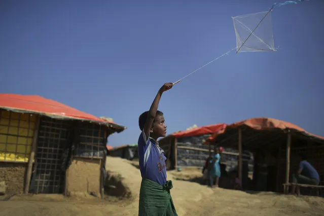 In this November 21, 2017, file photo, a Rohingya Muslim flies his kite outside his family's tent, in Kutupalong refugee camp in Bangladesh. Since late August, more than 620,000 Rohingya have fled Myanmar's Rakhine state into neighboring Bangladesh, seeking safety from what the military described as “clearance operations”. (Photo by Wong Maye-E/AP Photo)