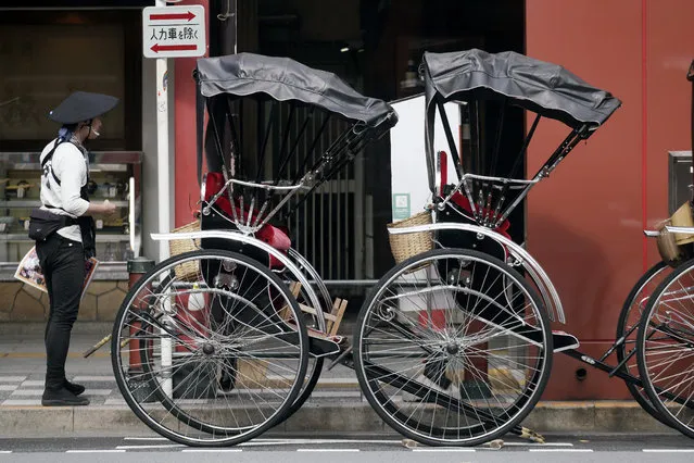 A rickshaw puller waits for tourists near Sensoji Temple in Asakusa district Thursday, October 22, 2020, in Tokyo. (Photo by Eugene Hoshiko/AP Photo)