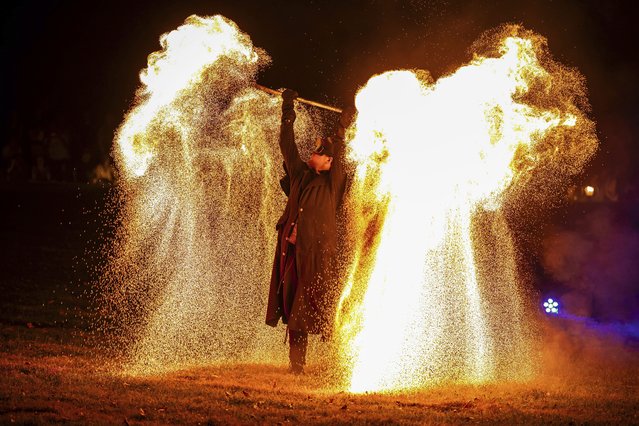A man performs a pyrotechnic show at the Palace of Versailles before the fireworks display in Versailles, outside Paris, Friday, August 15, 2025. (Photo by Aurelien Morissard/AP Photo)