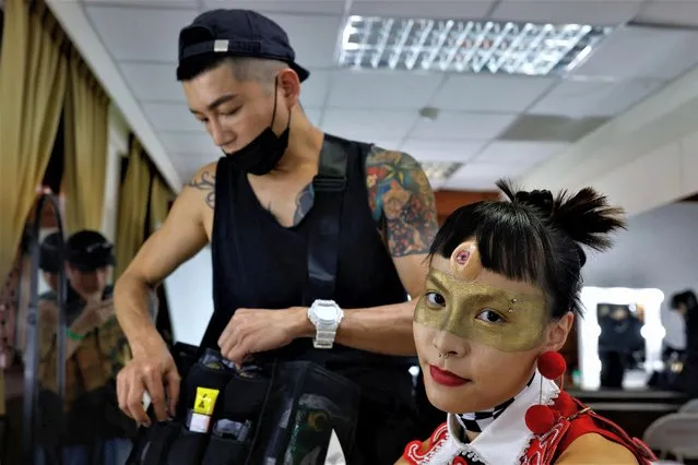 A model poses for a photo at the makeup room before the opening show of Taipei Fashion week which highlight the mix of using traditional and fashion at Tainan, Taiwan on March 22, 2023. (Photo by Ann Wang/Reuters)