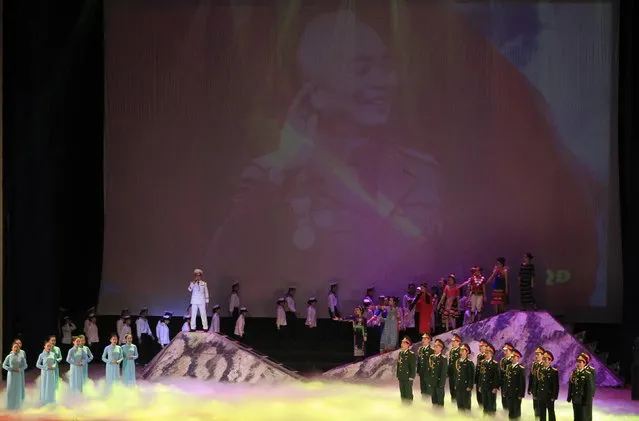 People perform in front of a screen showing an image of General Vo Nguyen Giap during celebrations to commemorate the 70th anniversary of the establishment of the Vietnam People's Army at the National Convention Center in Hanoi December 20, 2014. (Photo by Reuters/Kham)