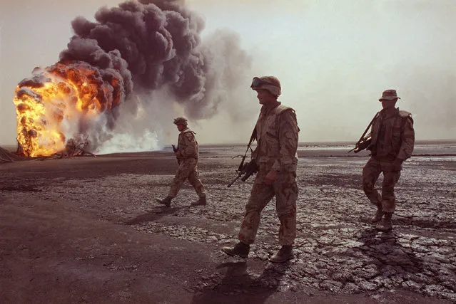 A U.S. Marine patrol walks across the charred oil landscape near a burning well during perimeter security patrol near Kuwait City on March 7, 1991. (Photo by John Gaps III/AP Photo)