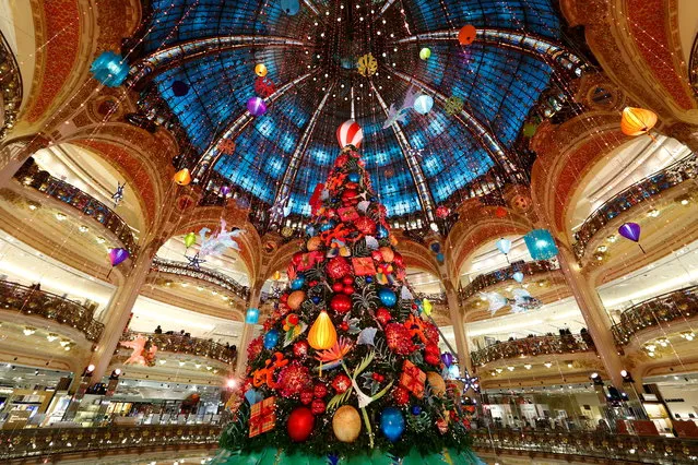 A giant Christmas tree stands at the Galeries Lafayette department store where lights were switched on for the festive season in Paris, France, November 30, 2020. (Photo by Gonzalo Fuentes/Reuters)