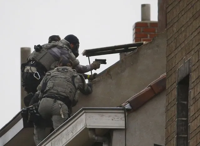 Belgian special forces police climb high on an apartment block during a raid, in search of suspected muslim fundamentalists linked to the deadly attacks in Paris, in the Brussels suburb of Molenbeek, November 16. 2015. (Photo by Yves Herman/Reuters)