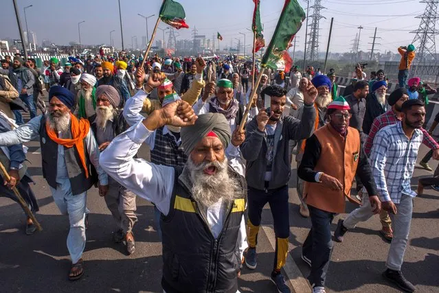 Indian farmers shout anti government slogans during a protest against new farm laws on December 13, 2020 at the Delhi-Uttar Pradesh border in Ghaziabad, India. As the protest over contentious farm laws continues to intensify, farmer unions on Saturday announced that they will observe an hunger strike on December 14 to press for their demands. The farmers on that day also plan to protest outside the offices of Prime Minister Narendra Modi's party across India. Hundreds of farmers from states like Punjab and Haryana have blocked some of the highways leading to Delhi borders for more than two weeks now against the new farm laws which they fear will prompt the government to stop making direct crop purchases at minimum state-set prices, called minimum support price. (Photo by Yawar Nazir/Getty Images)