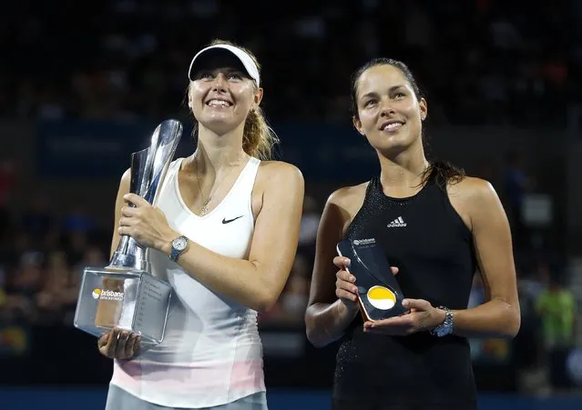 Maria Sharapova of Russia (L) holds the Brisbane International tennis tournament women's singles trophy after defeating Ana Ivanovic of Serbia (R) in Brisbane, January 10, 2015. (Photo by Jason Reed/Reuters)