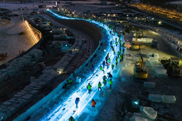 Aerial view of builders working on an ice slide at the construction site of the 27th Harbin Ice-Snow World at night on November 27, 2025 in Harbin, Heilongjiang Province of China. The ice construction for the 27th Harbin Ice-Snow World officially began on November 25. This year's park area has expanded to 1.2 million square meters, making it the largest edition in history. (Photo by Zhao Yuhang/China News Service/VCG via Getty Images)