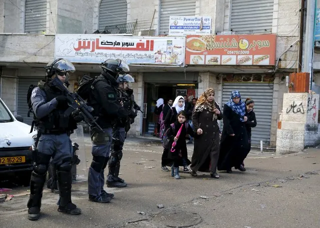 Israeli policemen stand guard during clashes that erupted after a house demolition in the East Jerusalem refugee camp of Shuafat, in an area Israel annexed to Jerusalem after capturing it in the 1967 Middle East war, December 2, 2015. A military spokesperson said on Wednesday that overnight security personnel demolished the residence of Ibrahim Mohammad Daud Achre in Jerusalem. They added that Achre murdered two Israelis in an attack on November 5, 2014 in Jerusalem. (Photo by Ammar Awad/Reuters)
