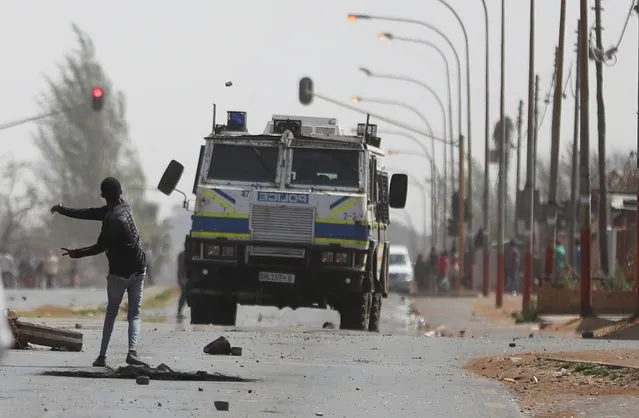 A man throws a stone at a police Inyala (armoured vehicle) during a protest demanding the police account for the death of the teenage boy who was allegedly shot by the police the previous night in Eldorado park, outside Johannesburg, South Africa on August 27, 2020. (Photo by Siphiwe Sibeko/Reuters)