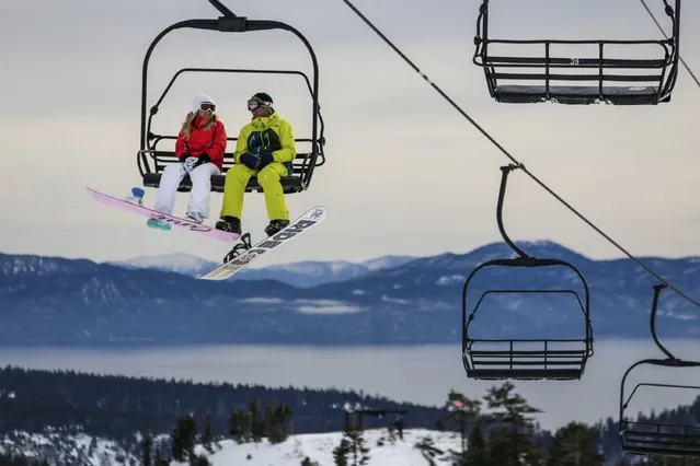 Snowboarders ride a lift with Lake Tahoe in the background at Squaw Valley in Olympic Valley, California, December 5, 2015. (Photo by Max Whittaker/Reuters)