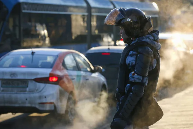 A police officer stands guard next to a building where a court will consider a motion from the Russian prison service to convert the suspended sentence of Russian opposition leader Alexei Navalny from the 2014 criminal conviction into a real prison term in Moscow, Russia, Tuesday, February 2, 2021. (Photo by Alexander Zemlianichenko/AP Photo)