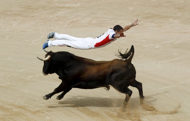 A "recortador" jumps over a bull during a contest at Pamplona's bullring during the San Fermin festival, Spain, July 11, 2015. (Photo by Joseba Etxaburu/Reuters)