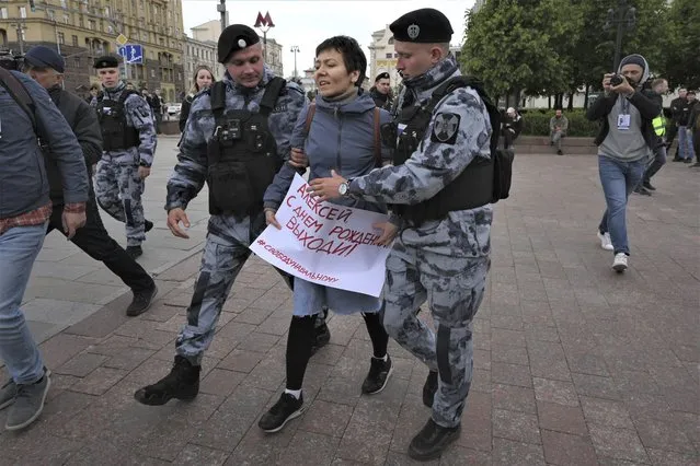 Police officers detain a demonstrator with a poster that reads: “Happy Birthday Alexei (Navalny)”, in Pushkinskaya Square in Moscow, Russia, Sunday, June 4, 2023. (Photo by AP Photo/Stringer)