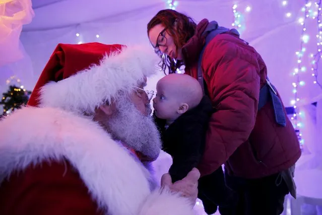 Six-month-old Cleo Matheson kisses actor John Field, dressed as Santa Claus, at a Christmas grotto at a dental practise in north London, Britain, December 12, 2015. (Photo by Stefan Wermuth/Reuters)