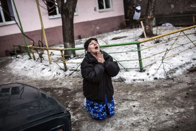 A Ukrainian woman begs Ukrainian President Petro Poroshenko to stop the bombing in Donetsk after shell hit the residential area where she lives, killing two civilians in Donetsk's Kyibishevsky district, on January 29, 2015. (Photo by Manu Brabo/AFP Photo)