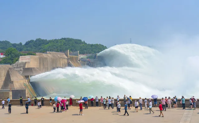 Tourists watch water gushing out from the Xiaolangdi Reservoir on the Yellow River on June 27, 2023 in Jiyuan, Henan Province of China. (Photo by Li Peixian/VCG via Getty Images)
