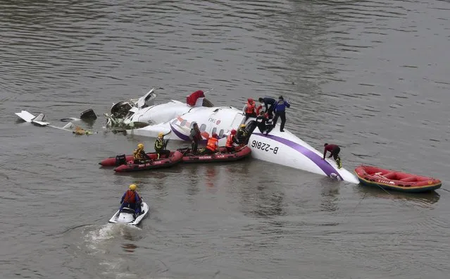 Rescuers carry out a rescue operation after a TransAsia Airways plane crash landed in a river, in New Taipei City, February 4, 2015. (Photo by Reuters/Stringer)