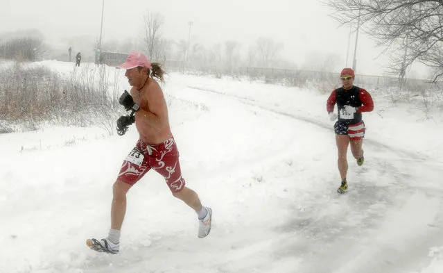 Runners brave the blowing snow during the Super Bowl Shuffle 5K in Geneva, Ill., Sunday, February 1, 2015. A slow-moving winter storm blanketed a large swath of the Plains and Midwest in snow Sunday, forcing the cancellation of more than 1,500 flights and making roads treacherous. (Photo by Mark Black/AP Photo/Daily Herald)