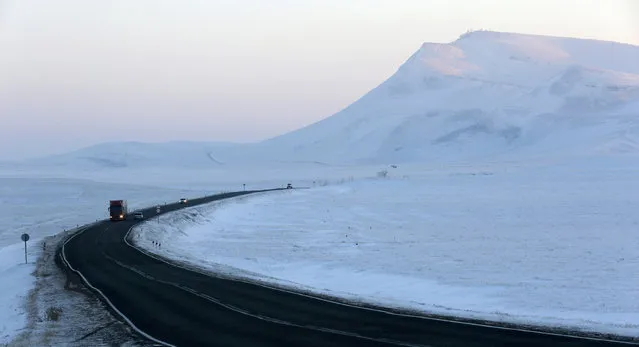 Vehicles drive along the 'Yenisei' federal highway through the steppe area, with the air temperature at about minus 25 degrees Celsius (minus 13 degrees Fahrenheit), in the Bogradsky district of Khakassia Republic in southern part of Siberia, Russia, January 4, 2016. The M54 'Yenisei' federal highway connects the regions of Krasnoyarsk, Khakassia and Tuva. (Photo by Ilya Naymushin/Reuters)