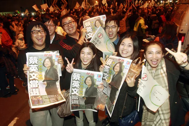 Supporters of Democratic Progressive Party, or DPP, presidential candidate Tsai Ing-wen show extra editions to cheer at the campaign headquarters as early polling numbers arrive in her favor, Saturday, January 16, 2016, in Taipei, Taiwan. Taiwanese voted for a new president Saturday, with the China-friendly Nationalist Party likely to lose power to the pro-independence opposition amid concerns that the island's economy is under threat from China and broad opposition to Beijing's demands for political unification. (Photo by Chiang Ying-ying/AP Photo)