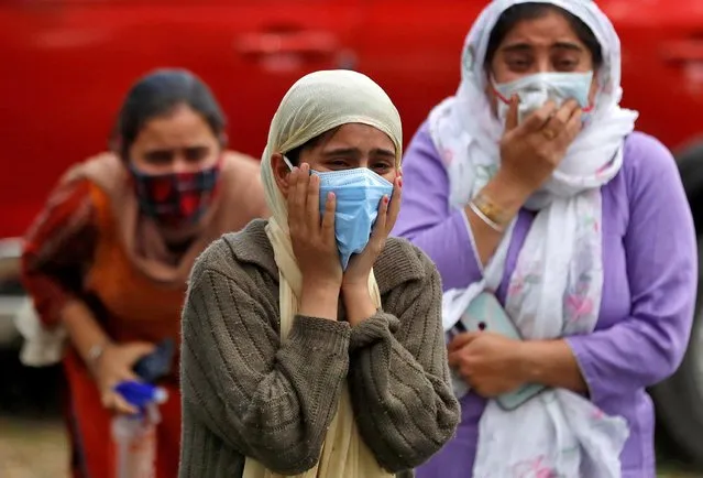 Relatives of a man who died from the coronavirus disease (COVID-19) mourn during his cremation at a crematorium ground in Srinagar on May 25, 2021. (Photo by Danish Ismail/Reuters)