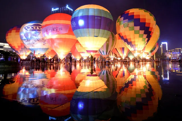 People look at hot air balloons decorating a plaza, during a tourism event in Guizhou province, China on October 15, 2018. (Photo by Reuters/China Daily)