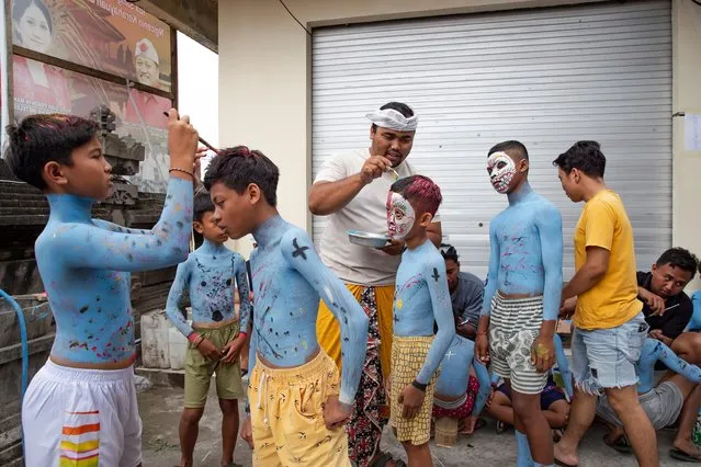 Young participants are helped to get their bodies and faces painted to attend the sacred Ngerebeg ritual at the Tegallalang village in Gianyar, Bali, Indonesia, 06 September 2023. (Photo by Made Nagi/EPA/EFE)
