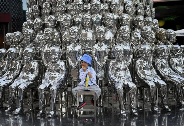 A boy sits on a chair amongst sculptures on display at a shopping centre on International Children's Day in Beijing on June 1, 2021, a day after China announced it would allow couples to have three children. (Photo by Noel Celis/AFP Photo)
