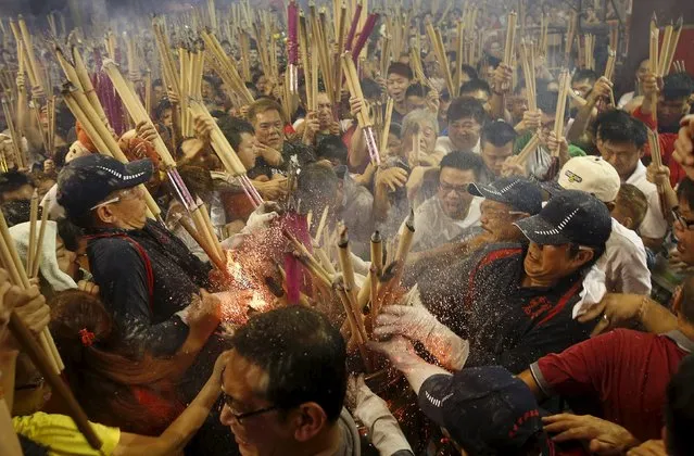 People rush to plant the first joss stick of the Lunar New Year of the Monkey at the stroke of midnight at the Kwan Im Thong Hood Cho temple in Singapore February 8, 2016. (Photo by Edgar Su/Reuters)