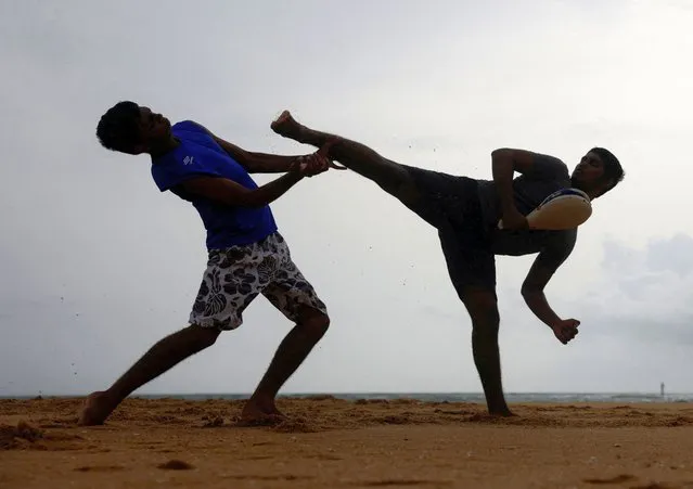 Two men perform martial arts on a beach in a suburb town of Colombo, Sri Lanka on July 2, 2023. (Photo by Dinuka Liyanawatte/Reuters)