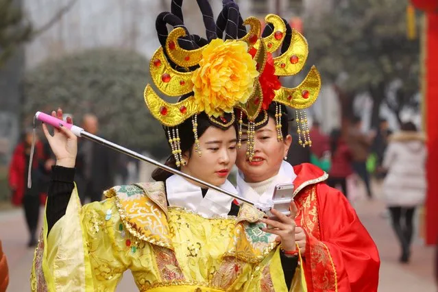 People wearing traditional costumes take selfies during a lantern fair at the beginning of Chinese Lunar New Year, in Xi'an, Shaanxi province, February 11, 2016. (Photo by Reuters/Stringer)