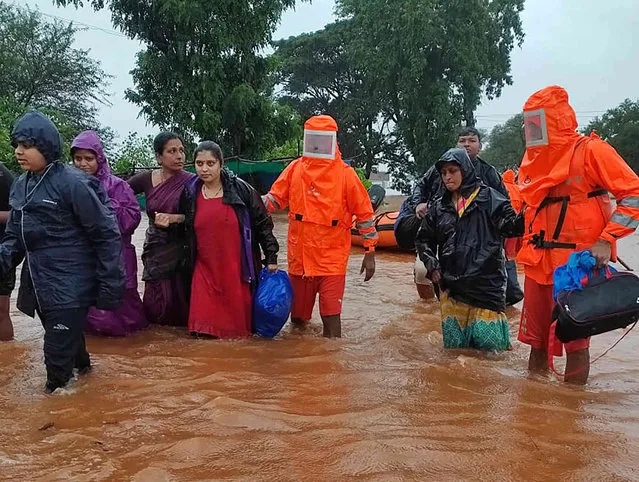 This photograph provided by India's National Disaster Response Force (NDRF) shows NDRF personnel rescuing people stranded in floodwaters in Chikhali, in the western Indian state of Maharashtra, Friday, July 23, 2021. Landslides triggered by heavy monsoon rains hit parts of western India, killing more than 30 people and leading to the overnight rescue of more than 1,000 other people trapped by floodwaters, officials said Friday.(Photo by National Disaster Response Force via AP Photo)