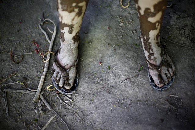 Feet of a child covered in mud are seen on a street which was hit by the floods at Los Loros town, April 7, 2015. (Photo by Ivan Alvarado/Reuters)