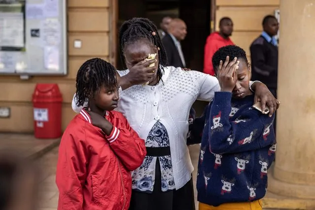 12-year-old Agnes Wanjiru's daughter Stacy Wanjiru (L), Agnes Wanjiru's sister Rose Wanyua (C) and Agnes Wanjiru's niece Esther Njoki (R) hug as they get emotional after the postponement of the hearing of the case for the alleged murder of Agnes Wanjiru by a British soldier at the Milimani Law Courts in Nairobi on November 29, 2023. Agnes Wanjiru, 21, was last seen alive with British troops at a hotel in the Kenyan town of Nanyuki in 2012, before body was found three months later at a septic tank near an army base. (Photo by Luis Tato/AFP Photo)