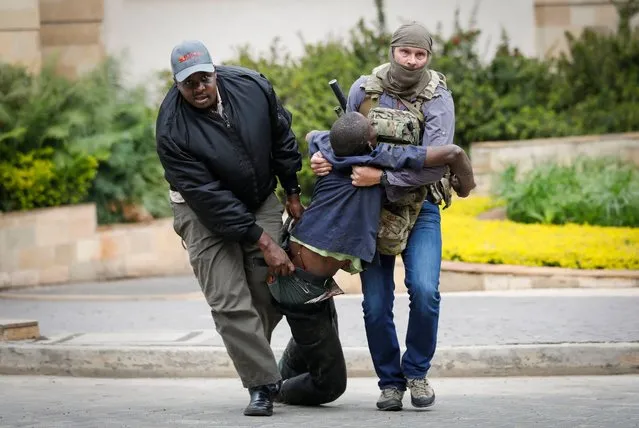 An injured man is escorted out of the scene by security officers during an ongoing gunfire and explosions in Nairobi, Kenya, 15 January 2019. According to reports, a large explosion and sustained gunfire sent workers fleeing for their lives at an upscale hotel and office complex in the Kenyan capital of Nairobi. (Photo by Dai Kurokawa/EPA/EFE/Rex Features/Shutterstock)