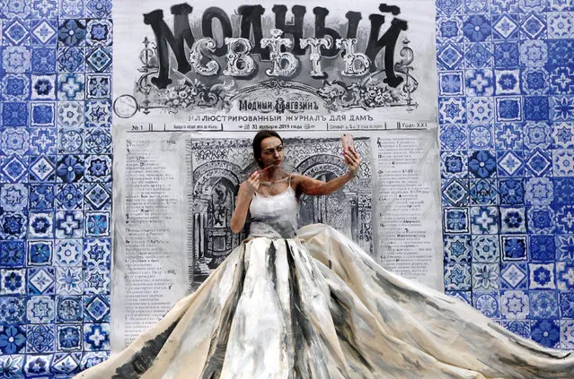 Russian artist Maria Gasanova adjusts her make-up as she finishes working on a body art creation, part of her “Alive Painting” project, during a fashion exhibition in the Siberian city of Krasnoyarsk, Russia on January 31, 2019. (Photo by Ilya Naymushin/Reuters)
