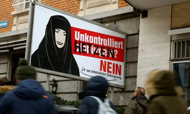 People walk past a poster of the Swiss Komitee gegen erleichterte Einbuergerung (Committee against an easier path to citizenship) that is covered with graffiti in Zurich, Switzerland January 19, 2017. The altered slogan reads “Unchecked incitement? No – Yes to an easier path to citizenship” instead of the original “Unchecked naturalization? No to an easier path to citizenship”. (Photo by Arnd Wiegmann/Reuters)