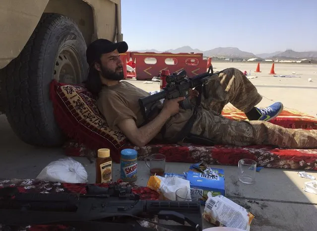 A Taliban fighter takes a rest inside the Hamid Karzai International Airport in Kabul, Afghanistan, Sunday, September 5, 2021. (Photo by Mohammad Asif Khan/AP Photo)