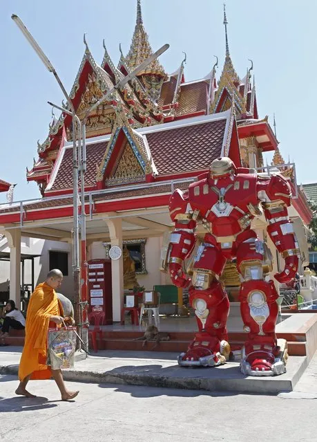 A Thai Buddhist monk walks past a statue depicting Iron Man, a US fictional superhero character, at Wat Tam Ru temple in Samut Prakan province, on the outskirts of Bangkok, Thailand, 26 February 2016. (Photo by Rungroj Yongrit/EPA)
