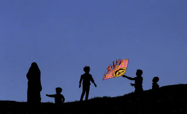 An Iranian boy flies a kite during the ancient festival of Sizdeh Bedar, an annual public picnic day on the 13th day of the Iranian new year, at the Pardisan Park in Tehran, Iran, Thursday, April 2, 2015. Iranians flocked to parks and wilderness on Thursday to mark the ancient festival, a legacy from pre-Islamic era, in the last day of Persian New Year holidays. (Photo by Vahid Salemi/AP Photo)