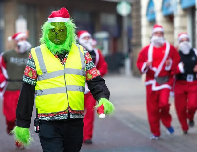 A person dressed in a Grinch costume takes part in the charity Santa Dash in Leeds, Britain, 11 December 2022. More than 500 runner took part in the event which is organized to raise funds for the St. Gemma's Hospice, a charity providing support for people in Leeds with life-threatening illnesses. (Photo by Adam Vaughan/EPA/EFE)