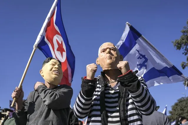 Protesters wear mask as Israeli Prime Minister Benjamin Netanyahu and North Korean leader Kim Jong Un during a protest against Benjamin Netanyahu's new government in front of Israel's Parliament in Jerusalem, Thursday, December 29, 2022. Netanyahu was set to return to office Thursday at the helm of the most religious and ultranationalist government in Israel's history, vowing to implement policies that could cause domestic and regional turmoil and alienate the country's closest allies. (Photo by Oded Balilty/AP Photo)