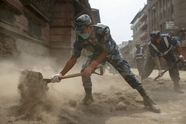 Nepal military personnel work to clear rubble along the street of Bashantapur Durbar Square, a UNESCO world heritage site, after the April 25 earthquake at Kathmandu in Nepal, May 7, 2015. (Photo by Athit Perawongmetha/Reuters)